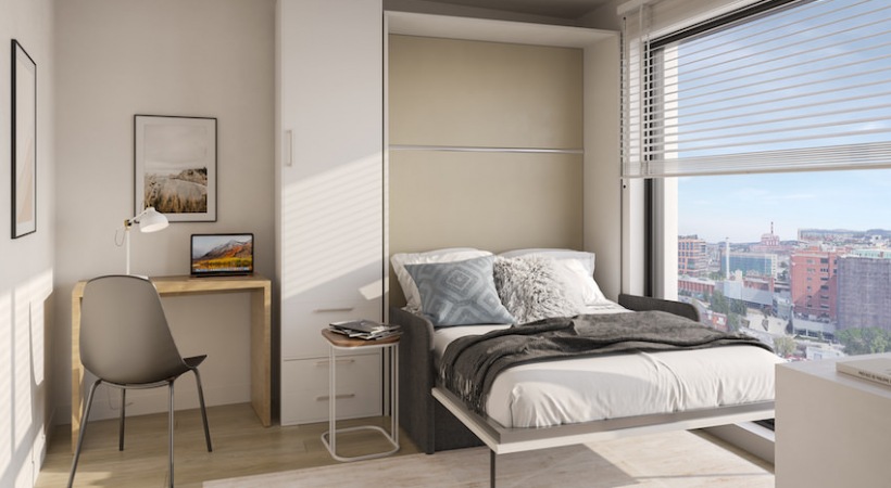 bedroom with murphy bed, desk and large floor-to-ceiling window
